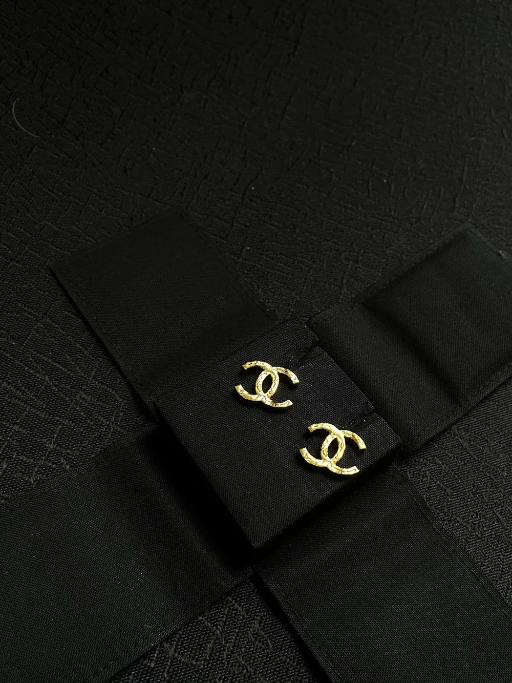 CHANEL Gold Interlocking CC Stud Earrings on Black